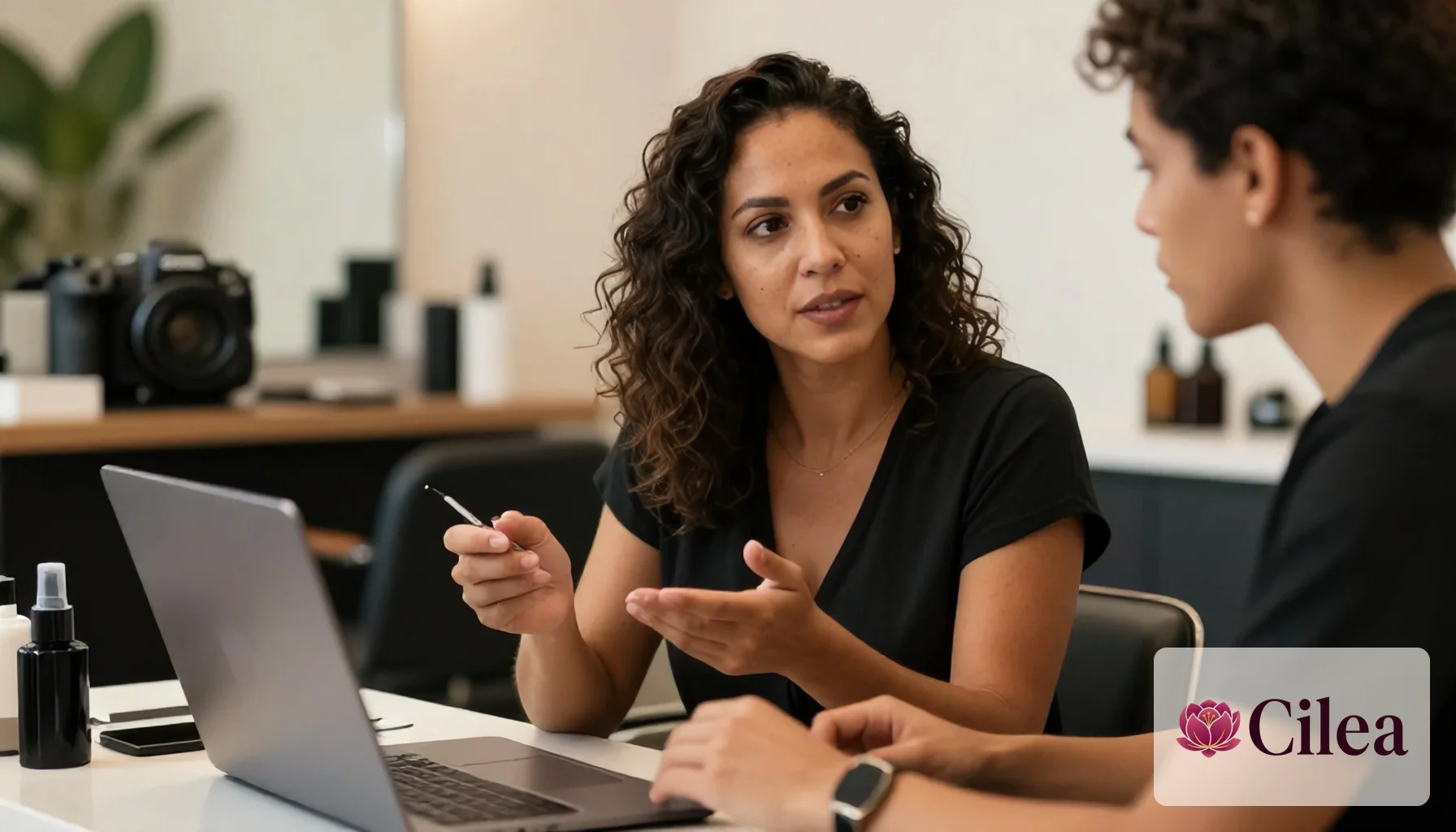 Dona de salão treinando funcionária no uso de sistema de gestão em notebook