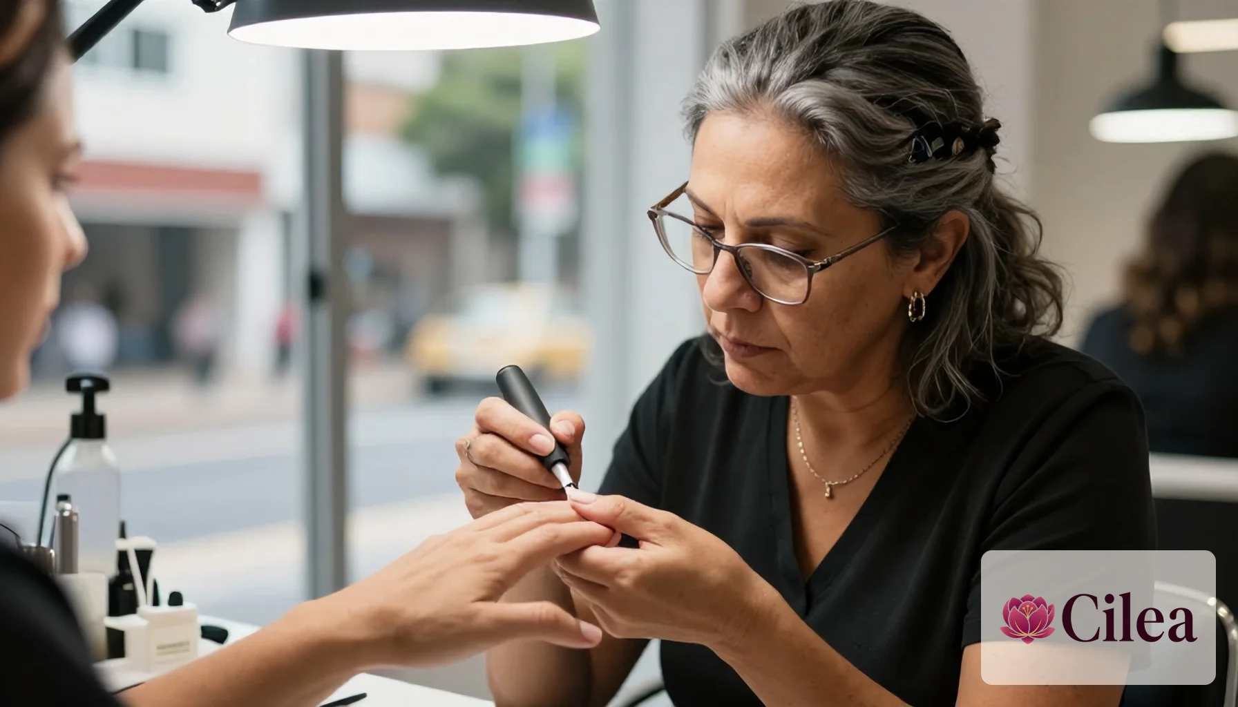 Profissional mulher pinta as unhas de cliente em salão de beleza durante curso de nail designer
