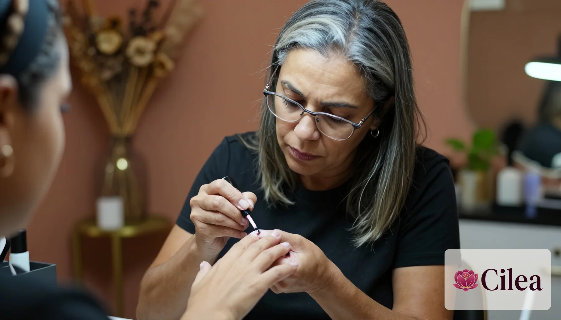 Mulher pintando as unhas de uma cliente no salão de beleza, focando no atendimento personalizado